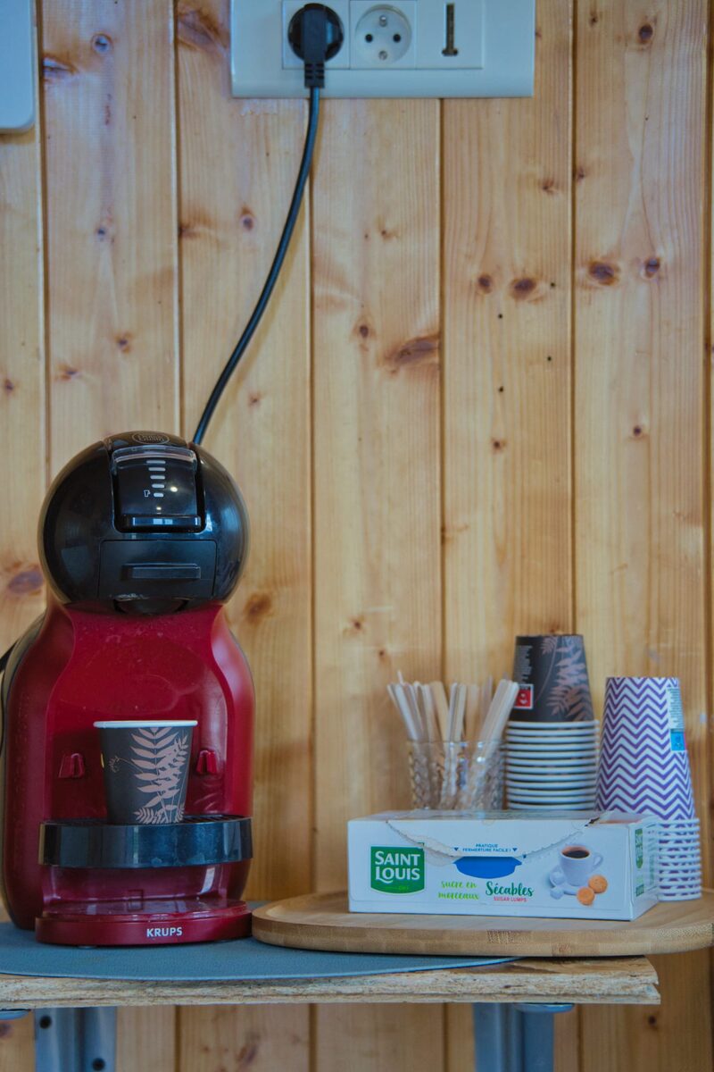 Coin café Dolce Gusto avec gobelets, sucre Saint Louis et plateau bois — offert aux clients