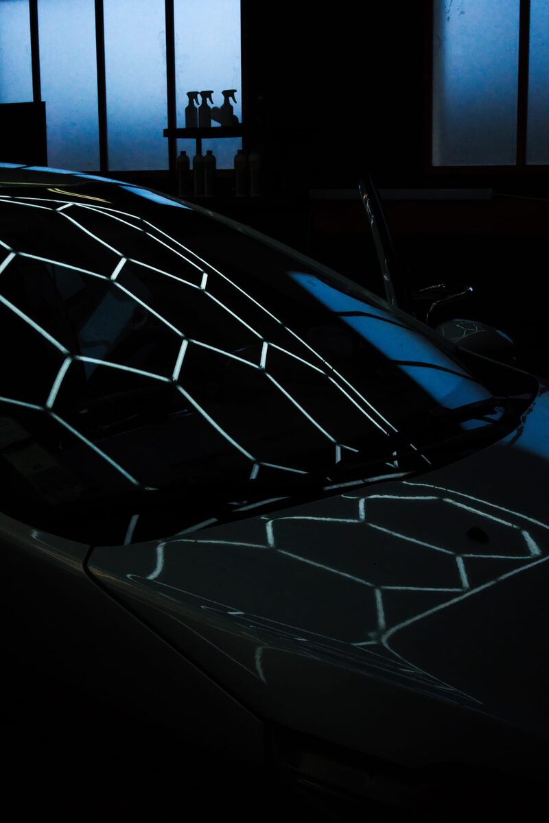 Reflet de la rampe hexagonale LED sur le capot brillant — preuve de polissage miroir