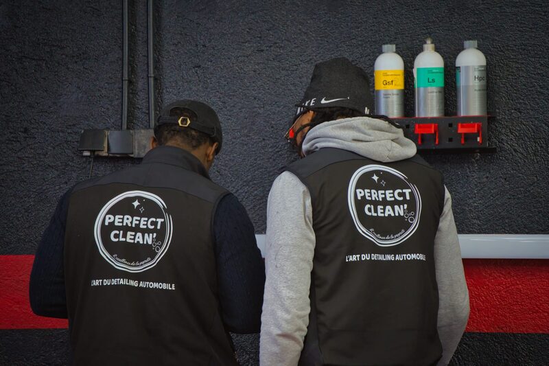 Le duo de détailleurs Perfect Clean 74 de dos, le logo brodé 'L'art du detailing automobile' parfaitement visible sur leurs vestes